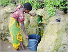Woman collecting spring water in Tanzania