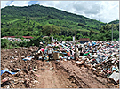 Typical scene of an access road to a final disposal site in the rainy season, when poor road conditions force waste trucks to dump waste on the road.