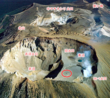 写真2 雌阿寒岳山頂全景(南側から撮影)<br />2006年撮影の写真と比べると、噴気が少なく火口底の様子がよくわかる。赤丸は斜め写真4と同じ箇所である。